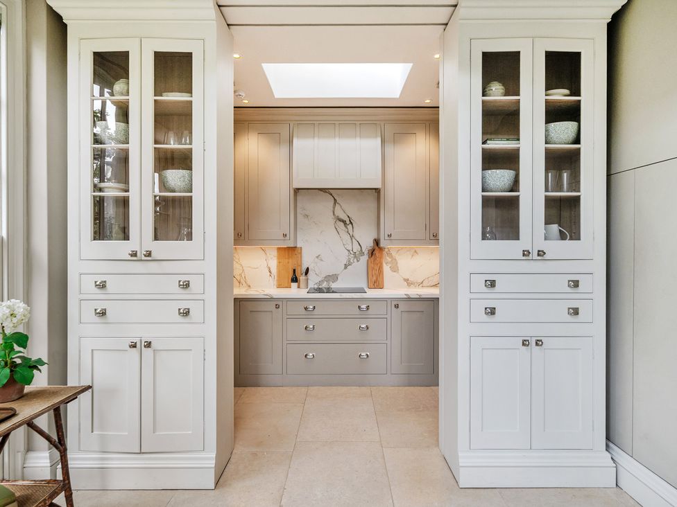 A kitchen with cabinets and countertop at Batheaston House in Batheaston