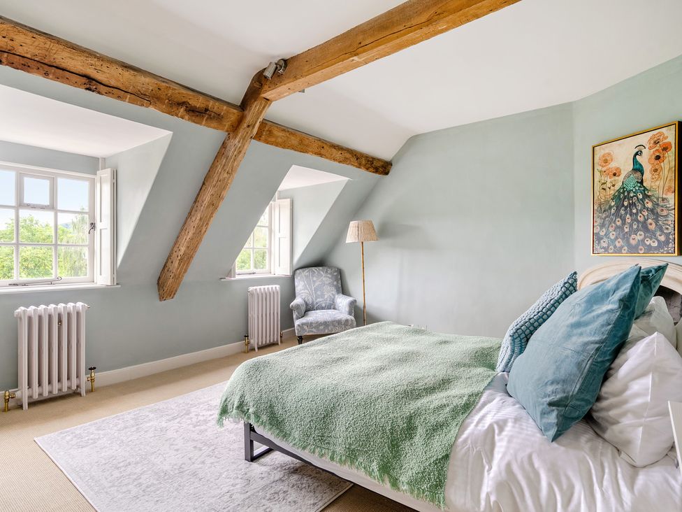 A bedroom with a bed and windows at Batheaston House in Batheaston