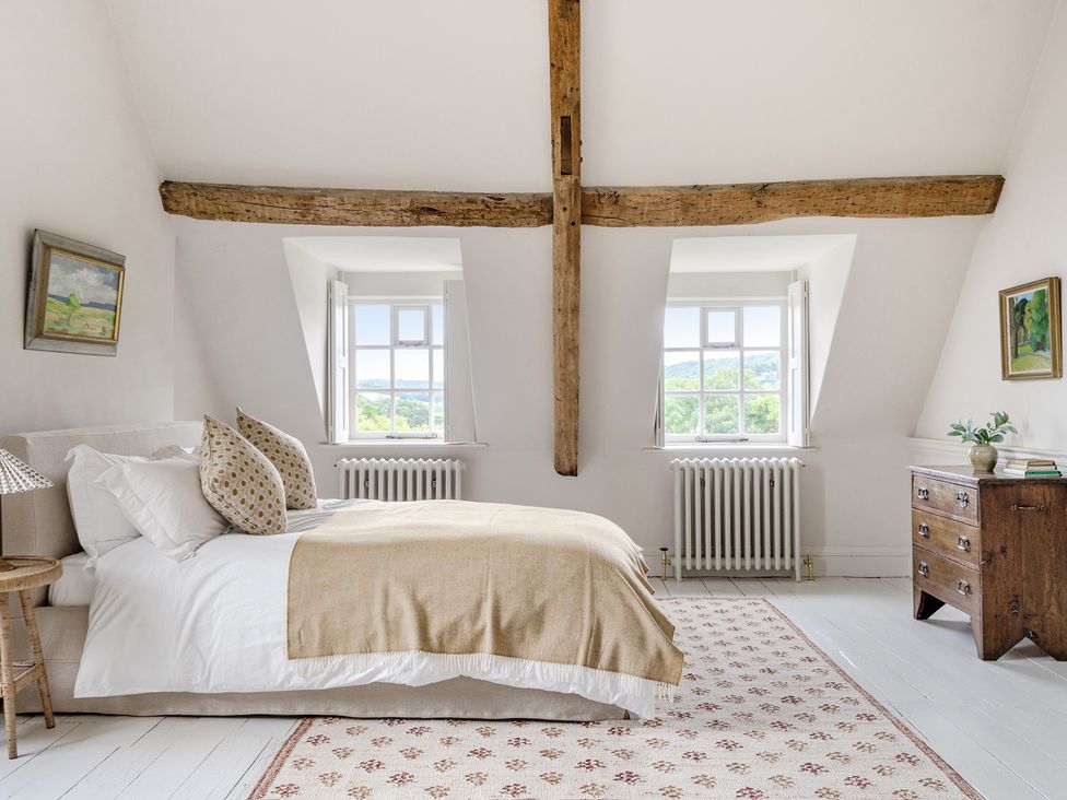 A bedroom with a bed and windows at Batheaston House in Batheaston