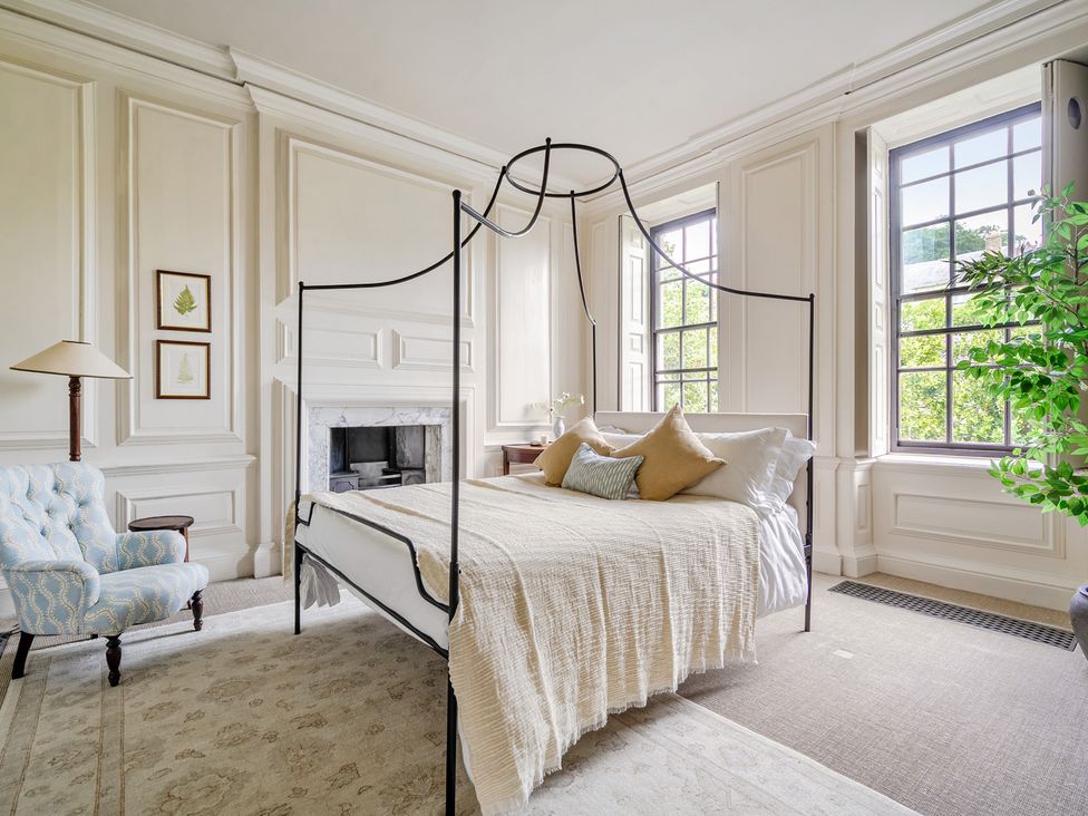 A bedroom with a bed and armchair at Batheaston House in Batheaston