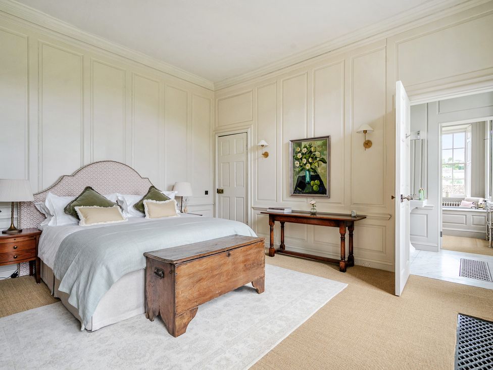 A bedroom with a bed and a console table at Batheaston House in Batheaston