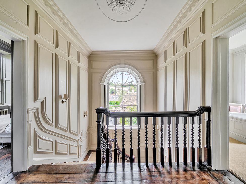 A hallway with a staircase and a window at Batheaston House in Batheaston