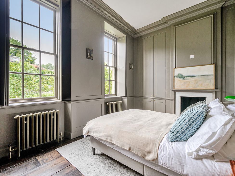 A bedroom with a bed and windows at Batheaston House in Batheaston