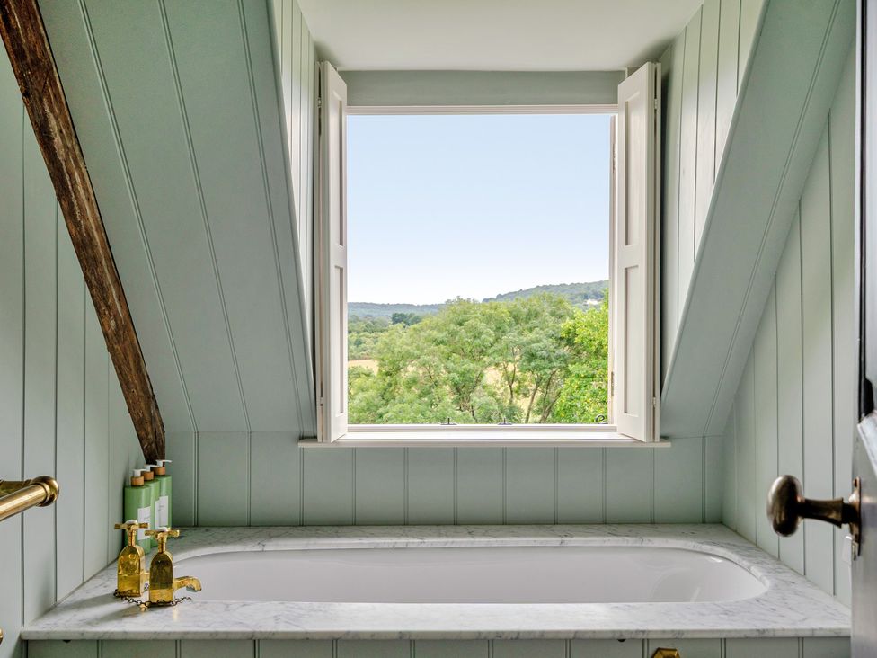 A bathroom with a bathtub and a window at Batheaston House in Batheaston