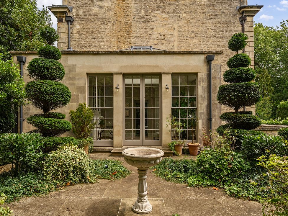 A garden with bushes and topiary at Batheaston House in Batheaston