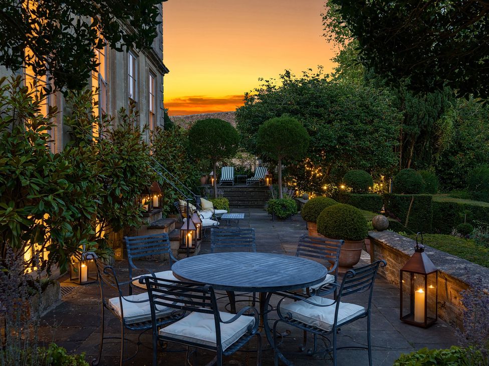 An outdoor seating area with a table and chairs at Batheaston House in Batheaston