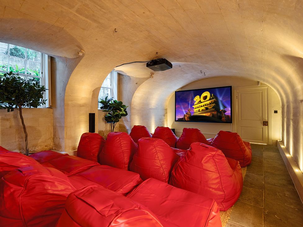 A media room with red bean bags and a projector at Batheaston House, Batheaston