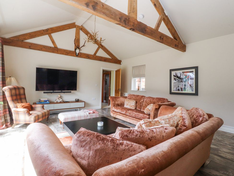 A living room with a television and seating area at The Old Coach House in Bilsborrow