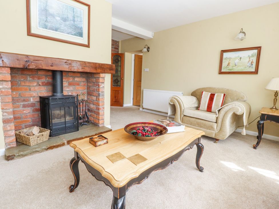 A living room with a fireplace and armchair at The Old Coach House in Bilsborrow