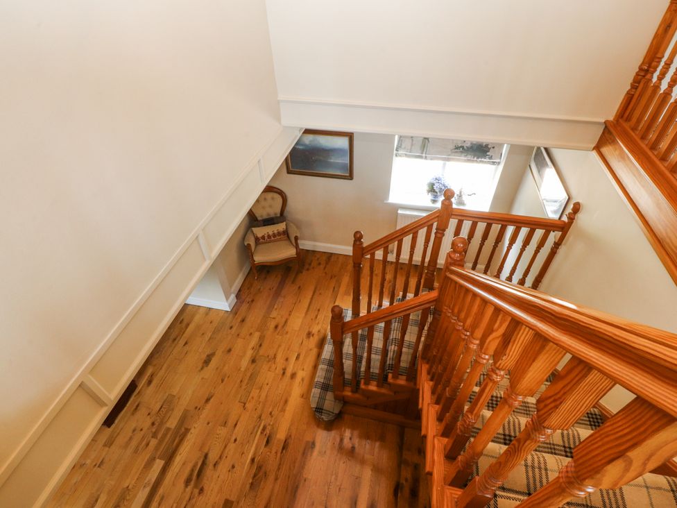 A staircase with a chair and window at The Old Coach House in Bilsborrow