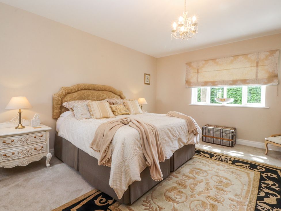 A bedroom with a bed and nightstand at The Old Coach House in Bilsborrow