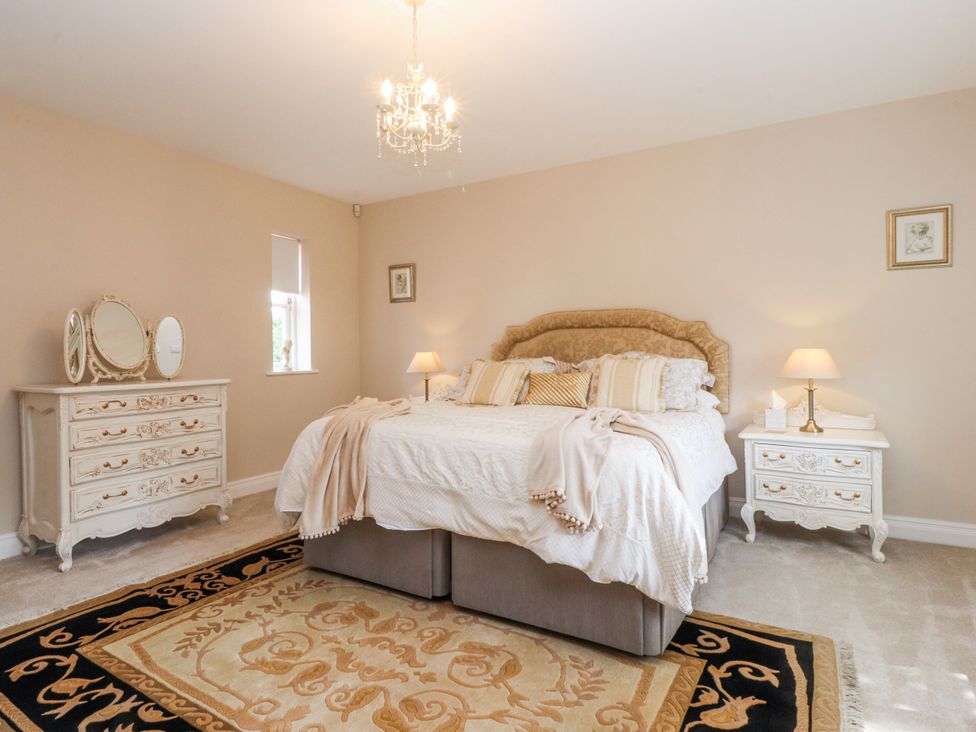A bedroom with a bed and dresser at The Old Coach House in Bilsborrow