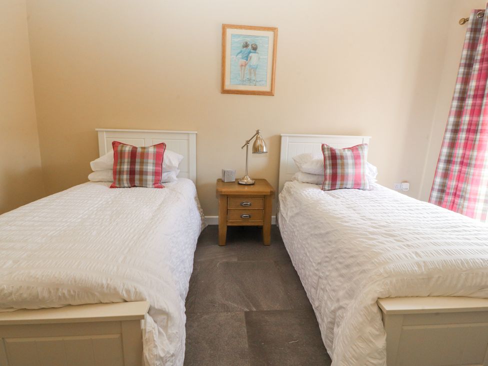 A bedroom with two beds and a bedside table at The Old Coach House in Bilsborrow