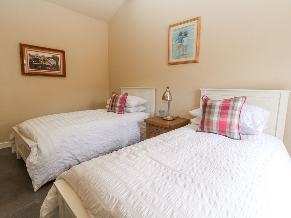 A bedroom with two single beds and a bedside table at The Old Coach House, Bilsborrow