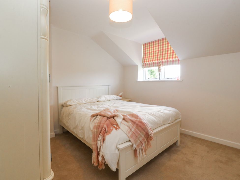 A bedroom with a bed and window at The Old Coach House in Bilsborrow