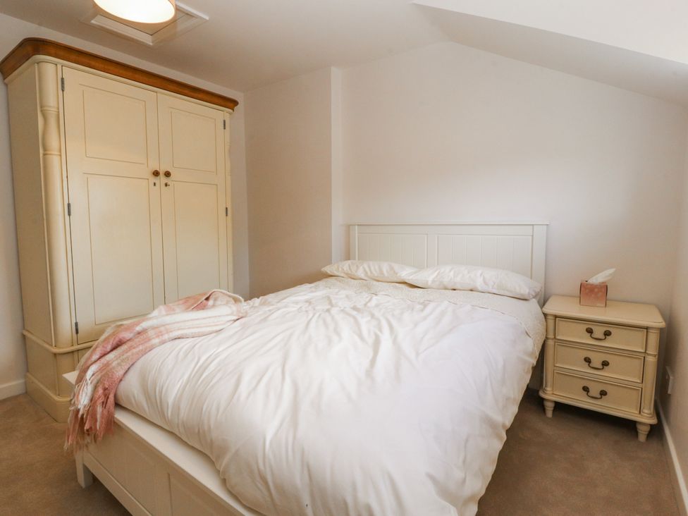 A bedroom with a bed and wardrobe at The Old Coach House in Bilsborrow