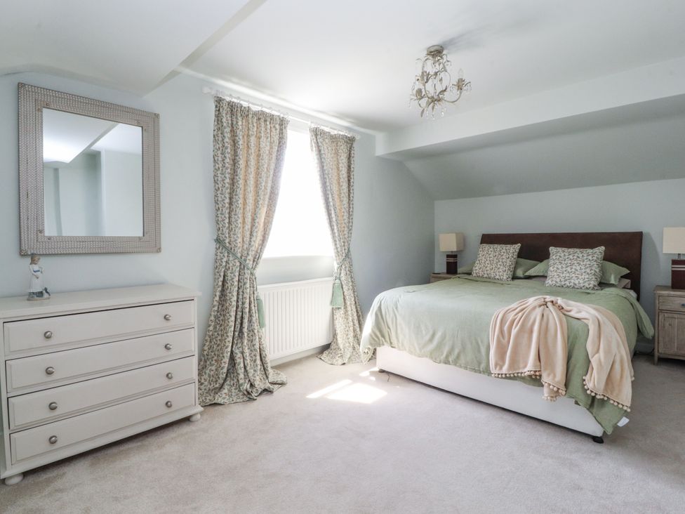 A bedroom with a bed, dresser, and mirror at The Old Coach House in Bilsborrow
