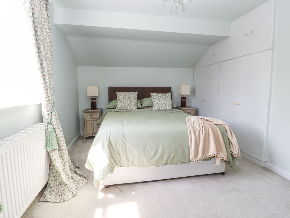 A bedroom with a bed and nightstands at The Old Coach House in Bilsborrow