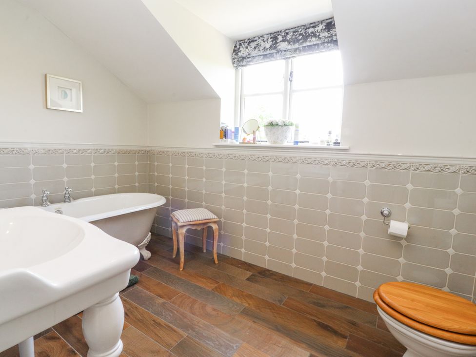 A bathroom with a bathtub, sink, and toilet at The Old Coach House in Bilsborrow