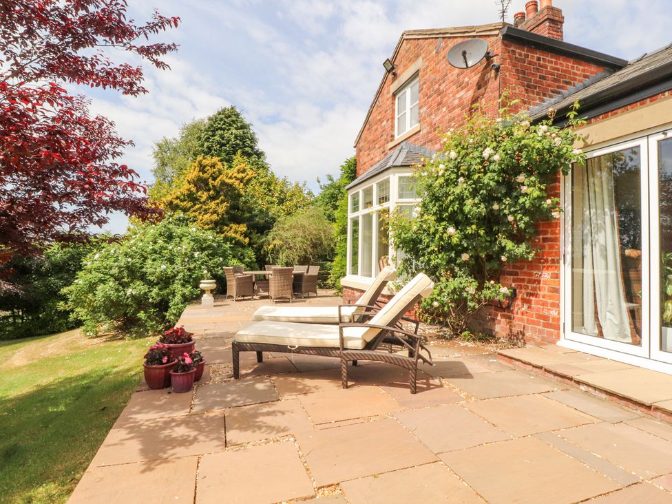 A patio with a lounge chair and dining area at The Old Coach House in Bilsborrow