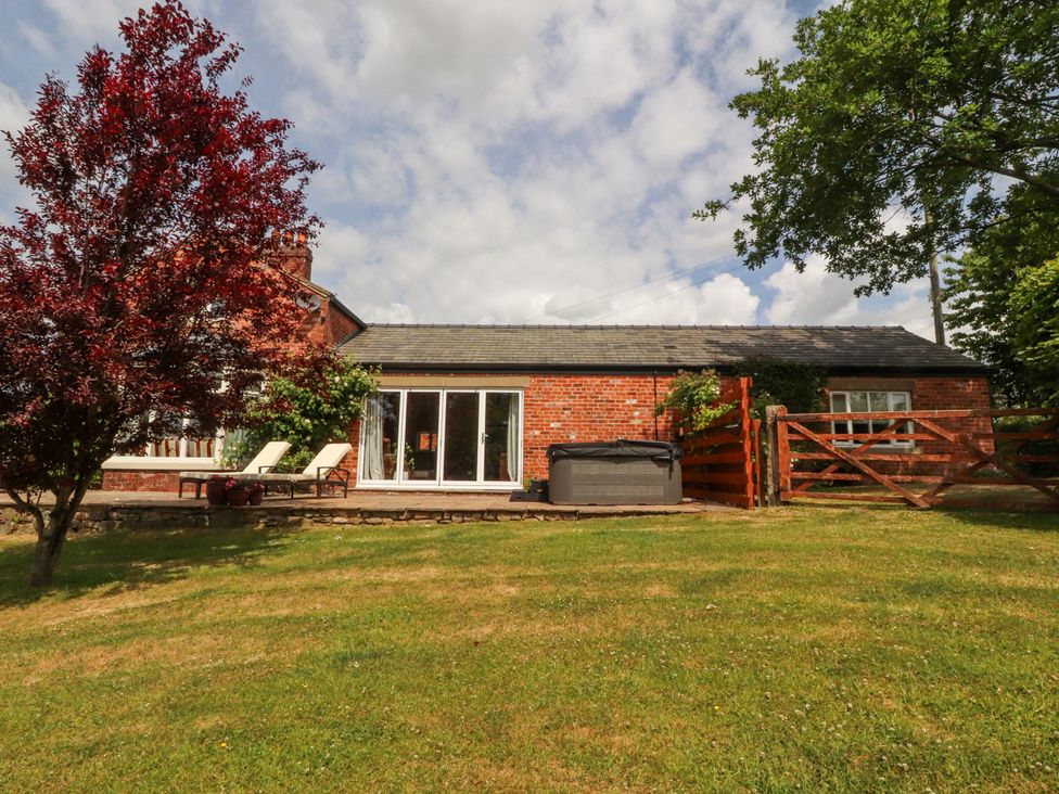 A house with a deck and hot tub at The Old Coach House in Bilsborrow
