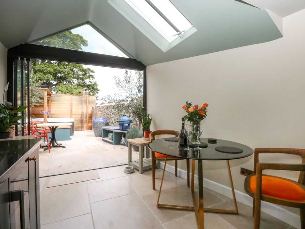 A dining room with a table and chairs at Hilltop Cottage in Conwy