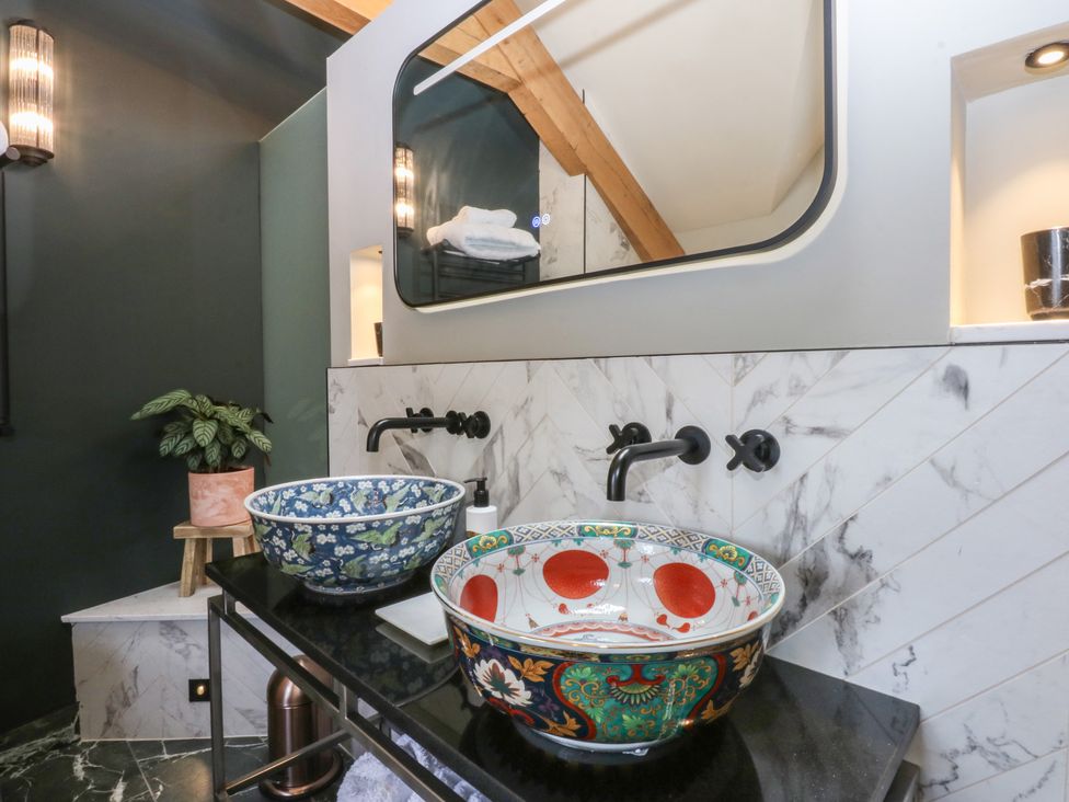 A bathroom with two sinks and decorative bowls at Hilltop Cottage in Conwy