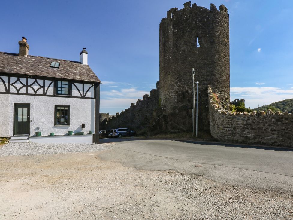 A house beside a stone tower and a road at Hilltop Cottage in Conwy