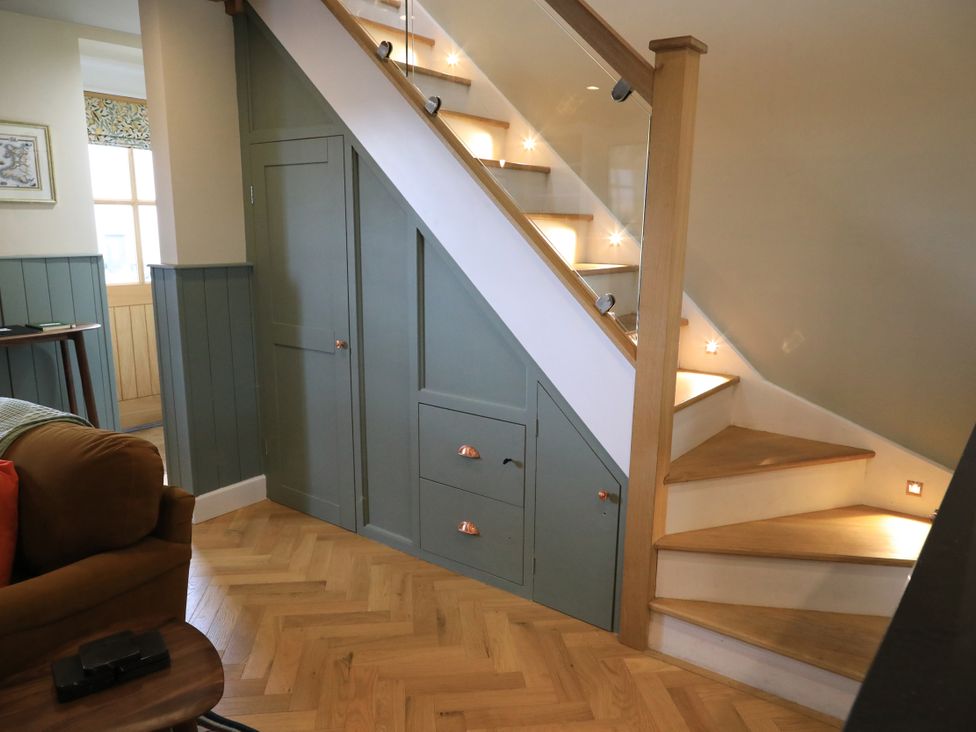 A staircase with storage cabinets in a hallway at Hilltop Cottage in Conwy