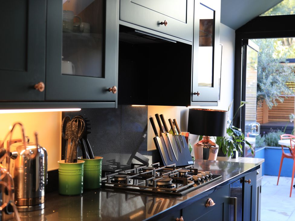A kitchen with cabinets and utensils at Hilltop Cottage in Conwy