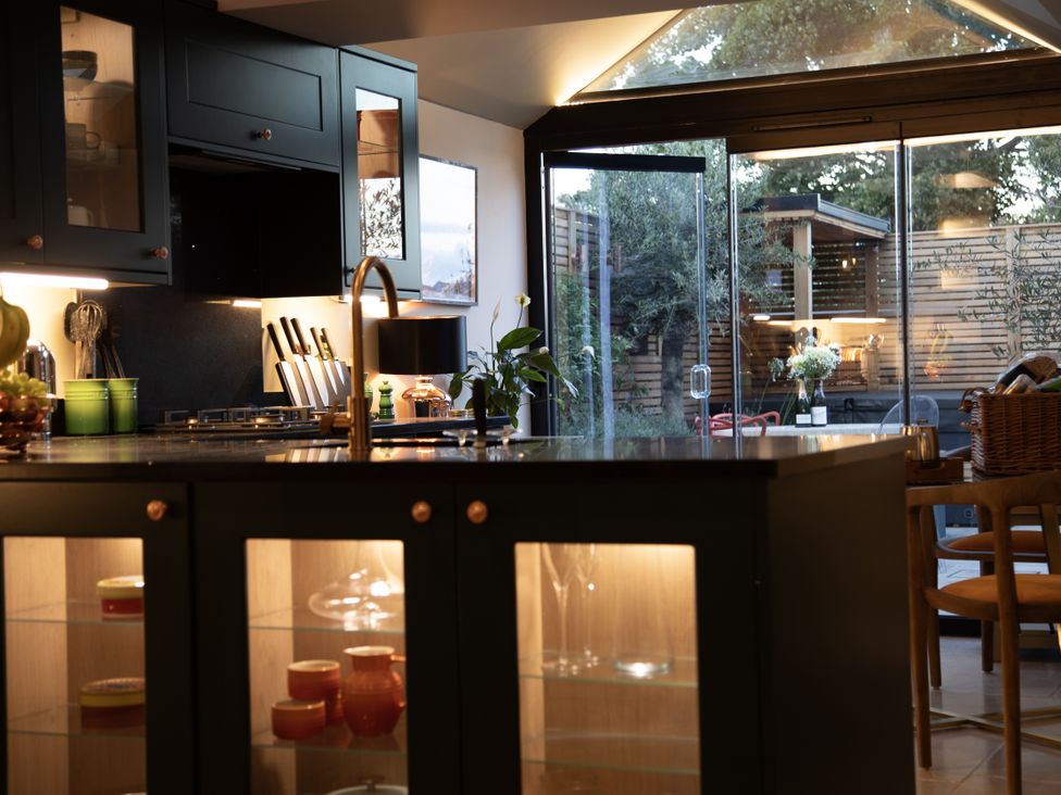 A kitchen with a counter, stove, and dining table at Hilltop Cottage in Conwy