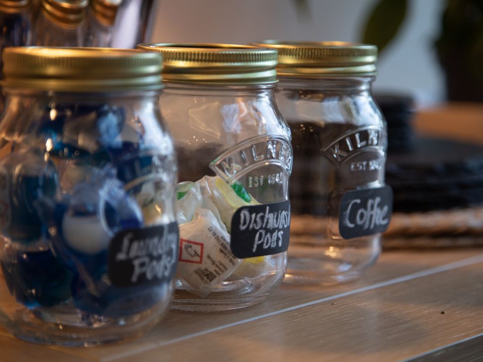 Jars containing laundry pods, dishwasher pods, and coffee at Hilltop Cottage in Conwy