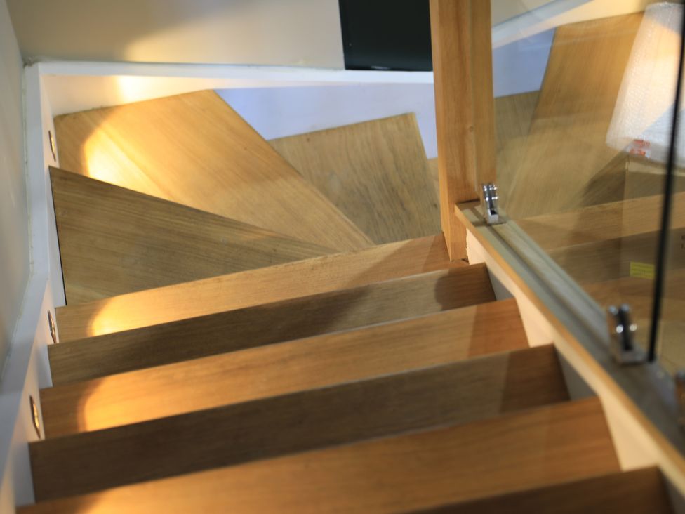 A staircase with wooden steps leading down at Hilltop Cottage in Conwy