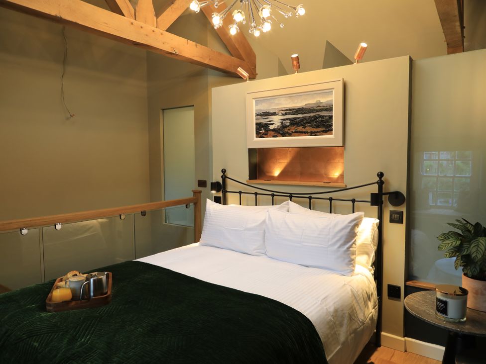 A bedroom with a bed and bedside table at Hilltop Cottage in Conwy