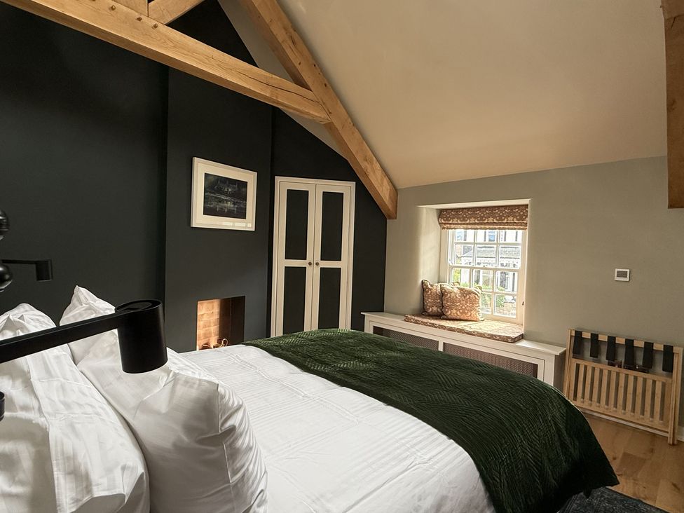 A bedroom with a bed and wardrobe at Hilltop Cottage in Conwy
