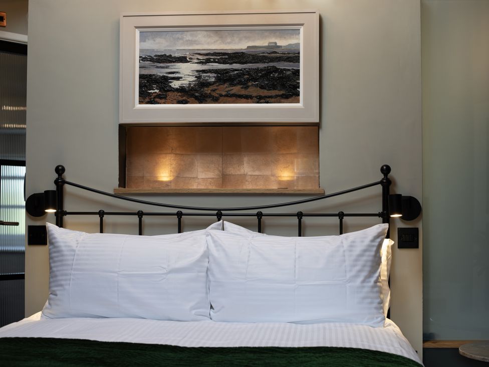 A bedroom with a bed and a painting at Hilltop Cottage in Conwy