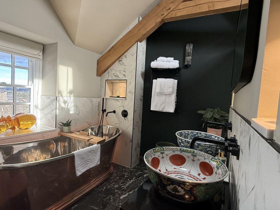 A bathroom with a bathtub and sinks at Hilltop Cottage in Conwy