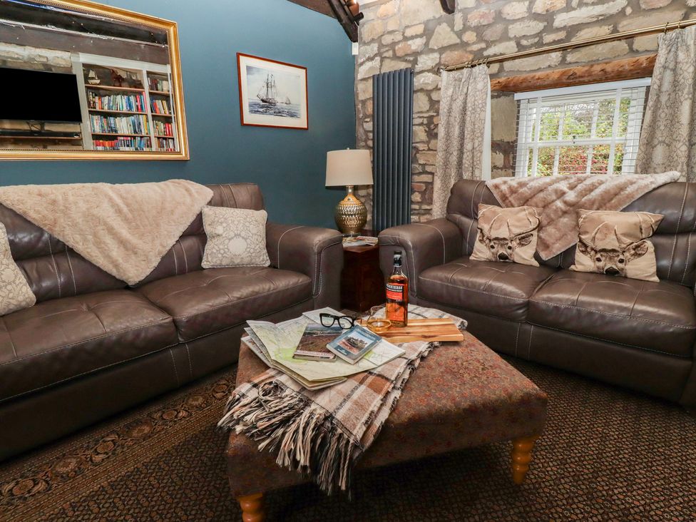 A living room with two brown sofas and a coffee table at The Poachers Pocket near Whittingham