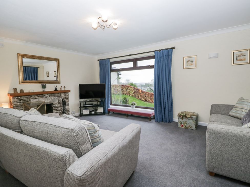 A living room with a television and sofa at Beech Brae in Kendal