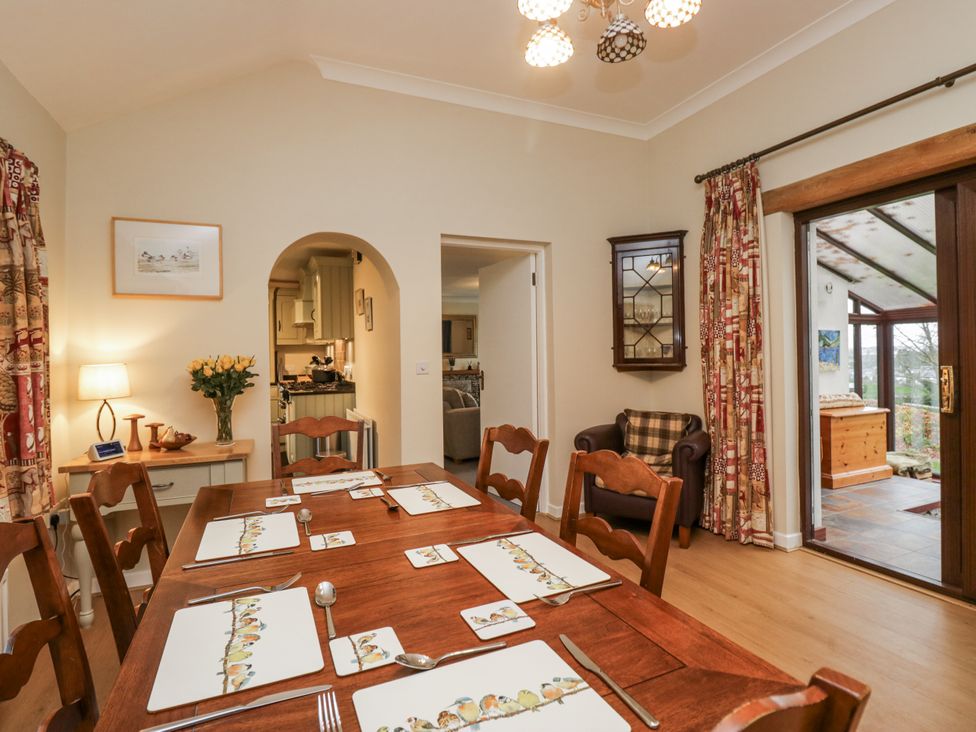 A dining room with a wooden table and chairs at Beech Brae in Kendal