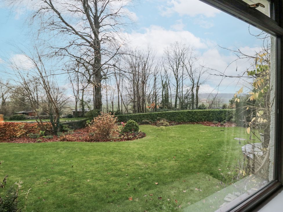A view of a garden with trees and hedges at Beech Brae in Kendal