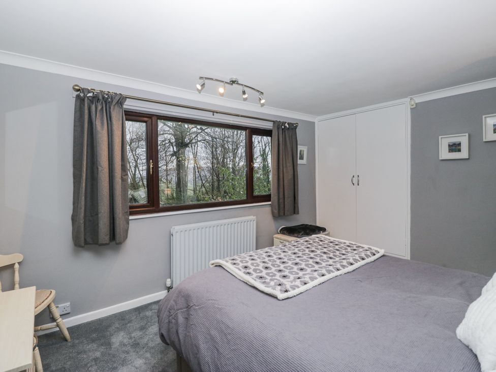 A bedroom with a bed and window at Beech Brae in Kendal