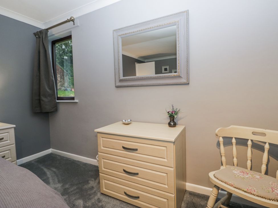 A bedroom with a drawer unit and a mirror at Beech Brae Kendal