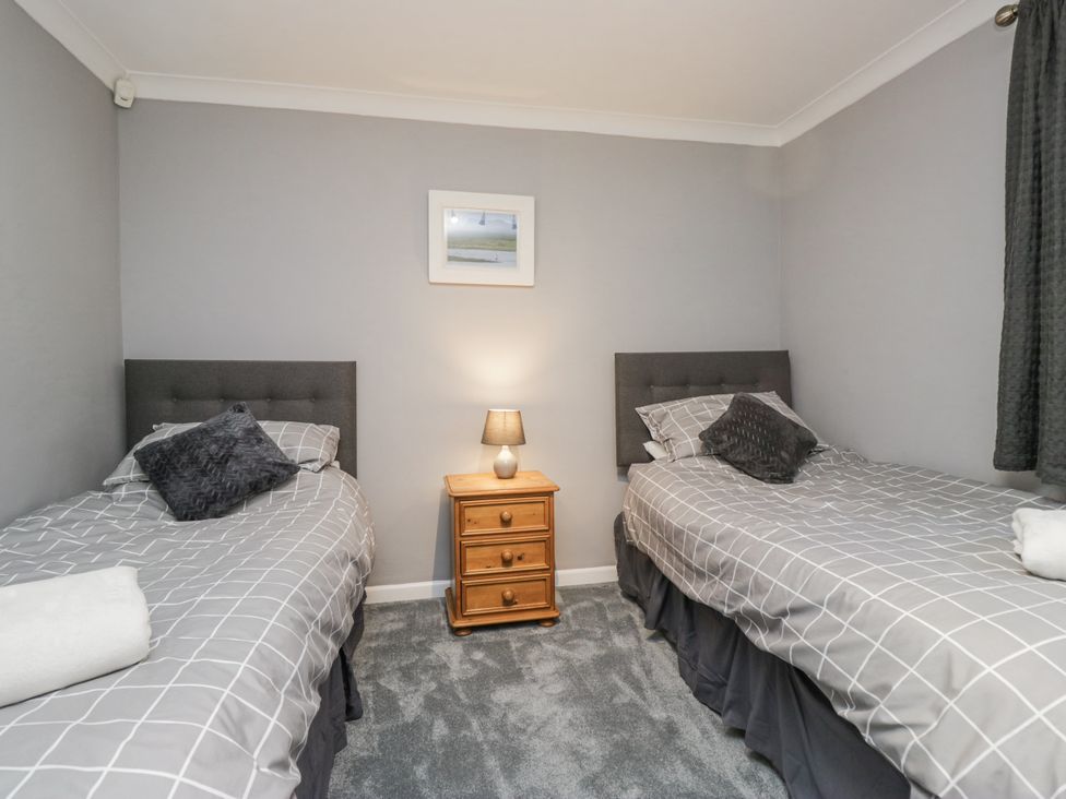 A bedroom with two single beds and a nightstand at Beech Brae Kendal