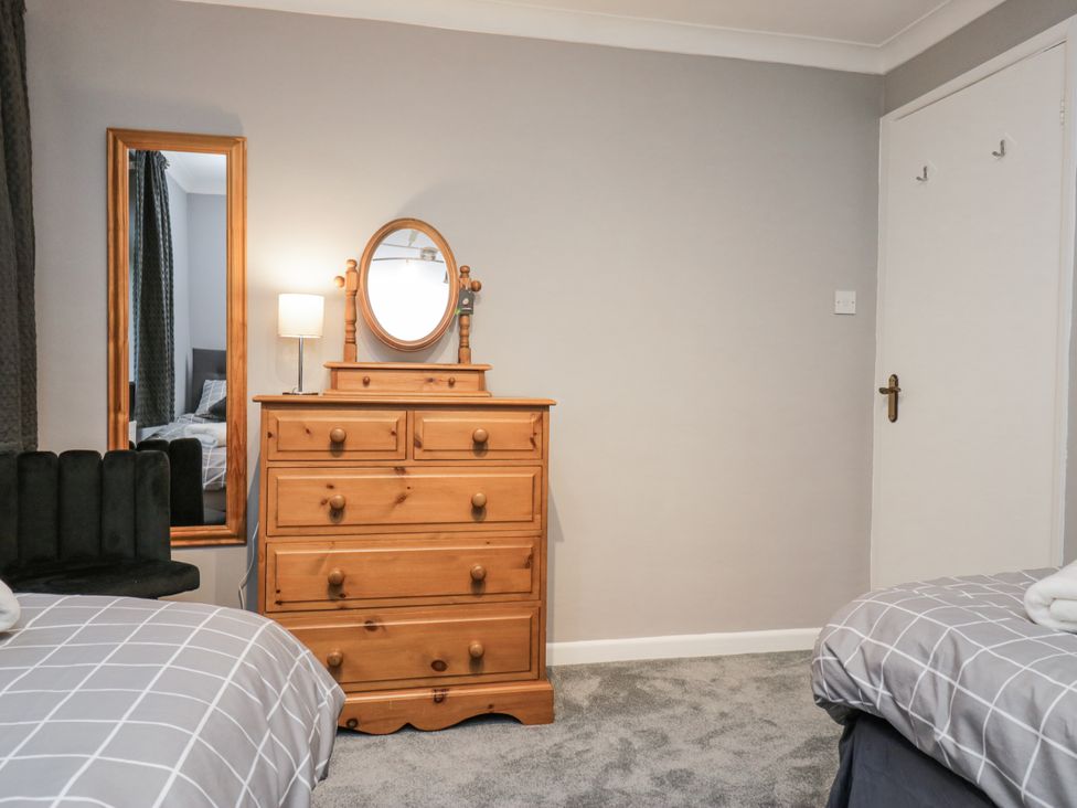A bedroom with a dresser and mirror at Beech Brae in Kendal