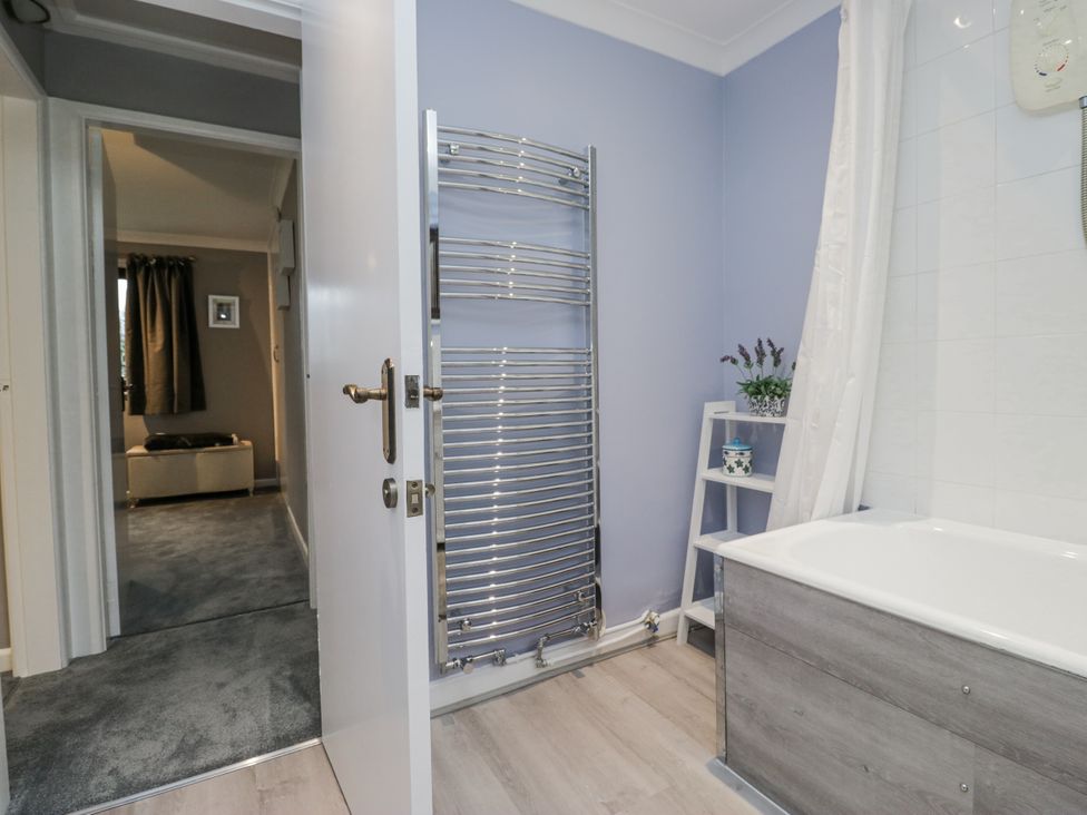 A bathroom with a bath tub and towel rack at Beech Brae in Kendal