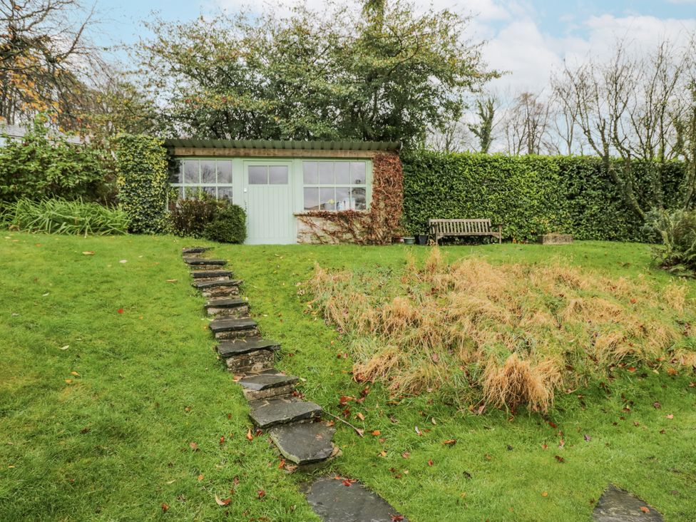 A garden with a shed and bench at Beech Brae in Kendal