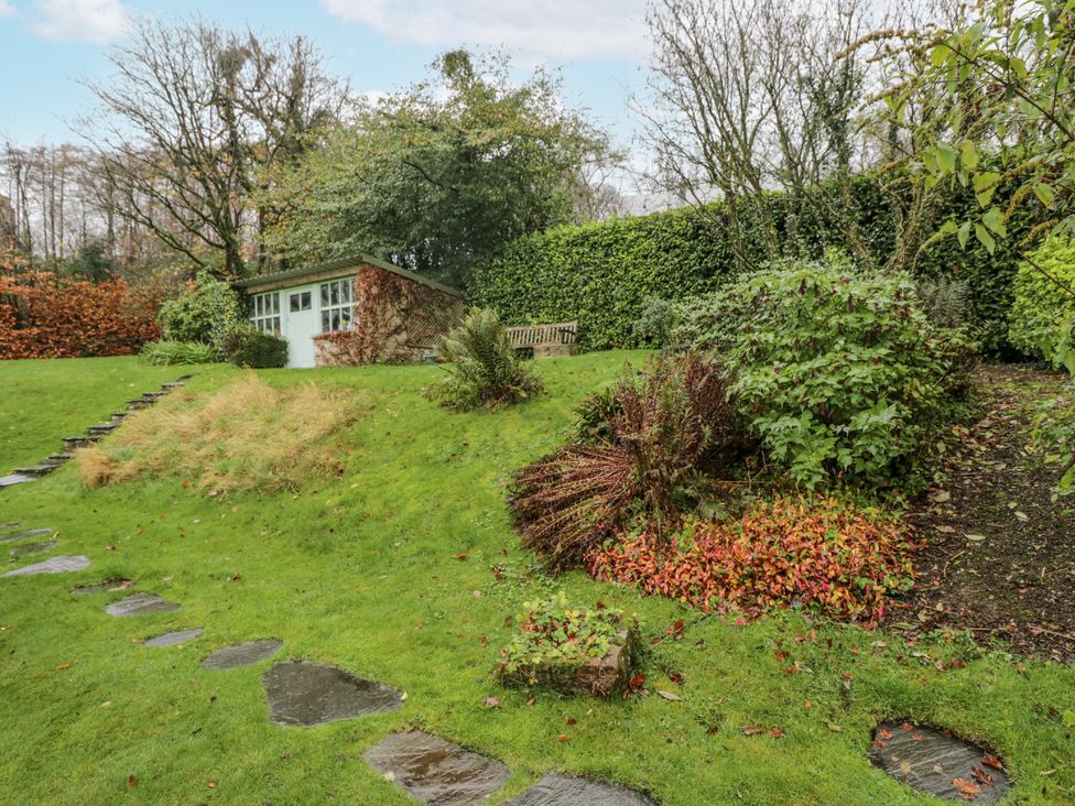 A garden with a shed and pathway at Beech Brae in Kendal