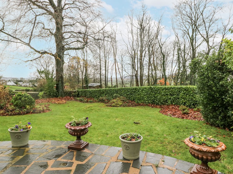 A garden with flower pots and trees at Beech Brae Kendal