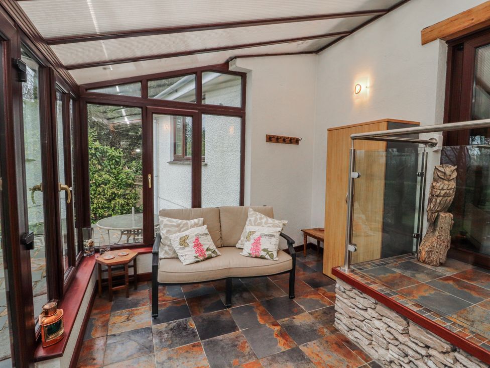 A conservatory with a sofa and coffee table at Beech Brae in Levens